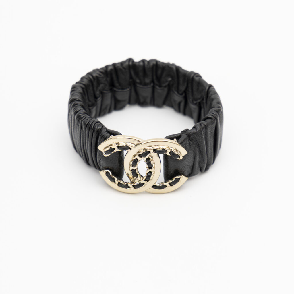 Pulsera Chanel Coco Mark B22P de piel con cierre tipo scrunchie, negra con detalles dorados